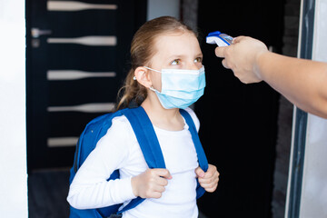Little girl is going back to school with the mask on her face