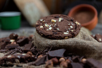 Chocolate cookies with hazelnuts , cocoa and pieces of dark chocolate on the rustic kitchen table