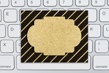 Blank gold glitter greeting card on a keyboard