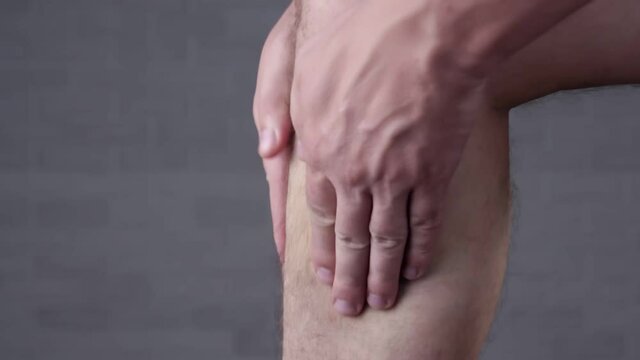 Man touches her painful shin. Health care and medical concept.