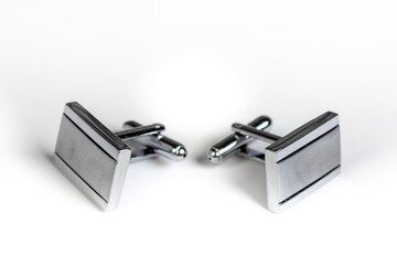 Cufflinks on a white background. An accessory for a men's shirt. Silver cufflinks. Free space for the inscription.