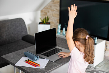 Little girl is back to school with the mask on her face, online education