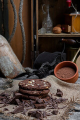 Chocolate cookies with hazelnuts , cocoa and pieces of dark chocolate on the rustic kitchen table