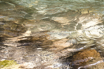 Stones under flowing water, texture, can be used as a background, horizontal frame, shooting from the side, close-up