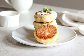 Sweet cheese pancakes with honey on a white plate. Homemade recipe cheesecakes.