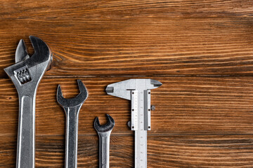 top view of different wrenches and calipers on wooden table, labor day concept
