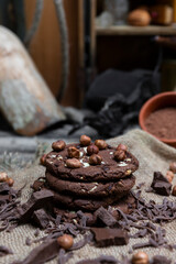 Chocolate cookies with hazelnuts , cocoa and pieces of dark chocolate on the rustic kitchen table