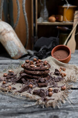 Chocolate cookies with hazelnuts , cocoa and pieces of dark chocolate on the rustic kitchen table
