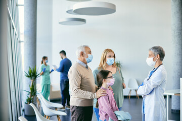 Extended family communicating with their family doctor at medical clinic during COVID-19 pandemic.