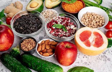 Fresh fruits, vegetables and seeds. Healthy food on a light stone background.