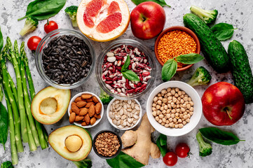 Fresh fruits, vegetables and seeds. Healthy food on a light stone background.