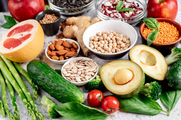 Fresh fruits, vegetables and seeds. Healthy food on a light stone background.