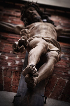 Bottom view of the crucifixion of Jesus Christ. Antique statue. Selective focus on foot sole