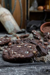 Chocolate cookies with hazelnuts , cocoa and pieces of dark chocolate on the rustic kitchen table