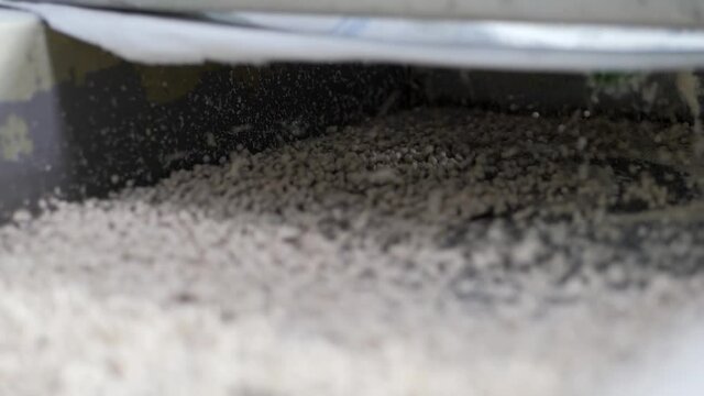 Plastic pellets jump on the grid of the vibrating table. Production of granular polyethylene.