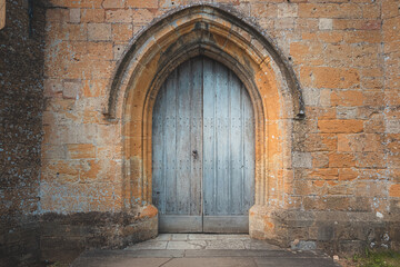 An old medieval, gothic church door at the historic Church of St James in the English village of...