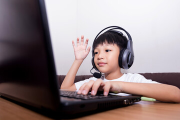 Asian boy student online learning class study online video call teacher. Happy child playing the game online with laptop stay at home.