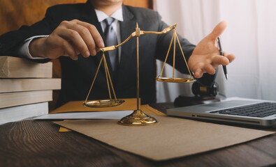 Justice and law concept.Male judge in a courtroom with the gavel, working with, computer and...