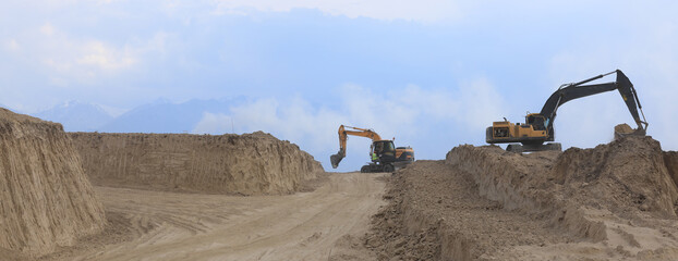 excavator digs the ground in summer © serikbaib