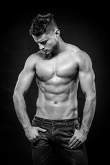 Fototapeta premium Young strong man on dark background