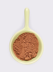 Small trial portion of cocoa powder on platter isolated on white background. Design element with clipping path