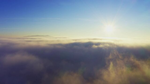 Wonderful view of extraordinary cloudy valley and bright orange sunset