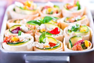 small Mexican tortilla rolls filled with minced meat with beans, feta, zucchini and paprika, crispy baked