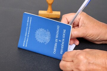 Person signing a Brazilian work card (carteira de trabalho). Employee hiring concept. 