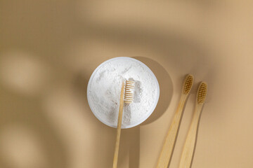 A set of eco friendly bamboo toothbrushes and white tooth powder on a beige pastel background. Zero waste, Sustainable lifestyle. Plastic free concept