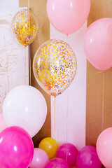 Pink and white baloons at reception hall.Balloons filled with helium,white and gold colors,tied with golden ribbons.Flying balls, as an essential accessory for celebrating birthday and other holidays.