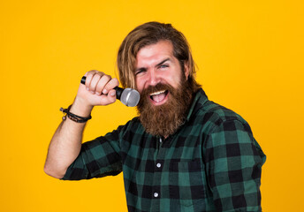 Bring music to life. mature guy sing song in microphone. karaoke. casual fashion styled singer. modern looking bearded hipster with mic. brutal handsome man with moustache singing