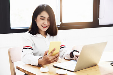 freelance concept,female using smartphone and computers to design work as ordered by customers.