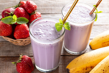 Fresh healthy strawberry smoothie on wooden background