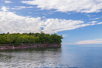 Coastline of Lake Superior with blue sky and white clouds, Michigan, USA
