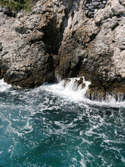 Azure sea waves hit the rocks in Kusadasi, Turkey.