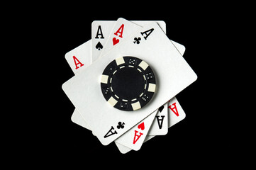 Poker game with four of kind combination. Chips and cards on the black table. Successful and maximum win