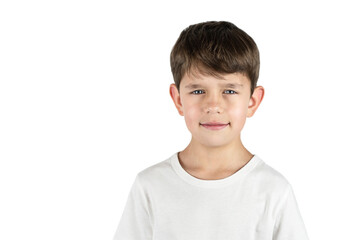 Little preschool boy in a light T-shirt on a white background, isolated. The boy has a serious face, he is waiting for his mother to return from work