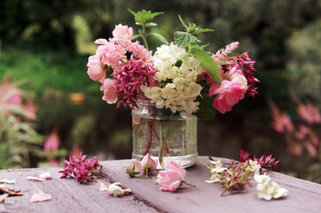 small bouquet of summer flowers on the table in the garden