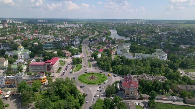 4k aerial view of roundabout road with circular cars in small european city at sunny day