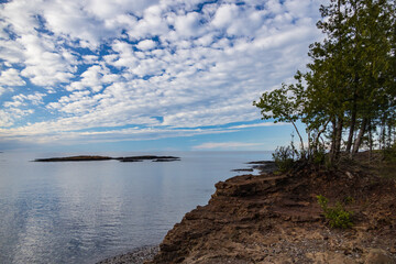 Fototapeta na wymiar Coastline of Lake Superior with blue sky and white clouds, Michigan, USA