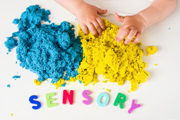 Sensory word and magic kinetic sand. Early sensory education. Kidd's sensory experiences, games and play for fine motor skills. Therapy hand, development of fine motor, autism, occupational therapy - obrazy, fototapety, plakaty