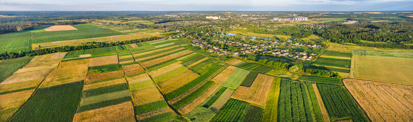 Fototapeta na wymiar European wide panorama with many fields on the countryside and little town near
