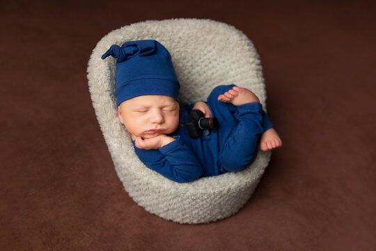 newborn in a chair with a toy camera. the first photo session of the child. baby photographer