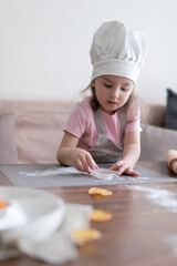 Cute little girl is playing in preparation of a cake