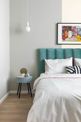 Cozy bedroom. Stylish modern interior design in grey, green and yellow tones. Decor on the nightstand