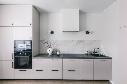 Minimalistic interior kitchen design. White grey marble kitchen room organization