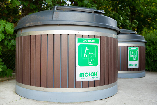 HAMILTON, Ontario, Canada - July 2021: Some Molok North America Ltd deep waste management  garbage bins in an outdoor area under the trees.