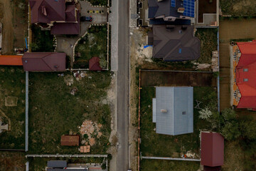 Aerial top view of a house with paved yard with green grass lawn with concrete foundation floor