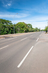 Large avenue with a separated bike lane and green trees around. Nelly Martins avenue at Campo...