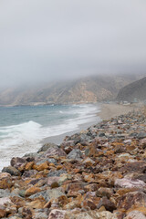 California Pacific Coast covered in fog, waves on the beach